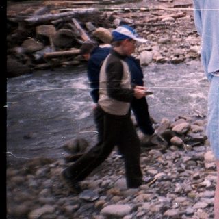 Group celebrating outdoors near river.