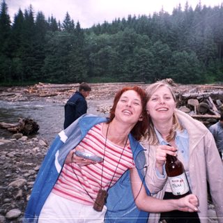 Two women laughing by a river.