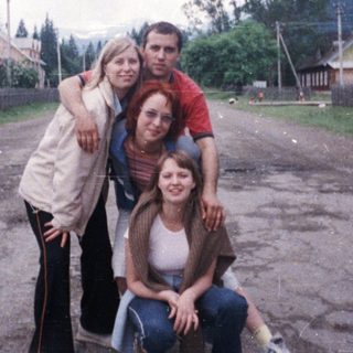 Group posing in rural village setting.