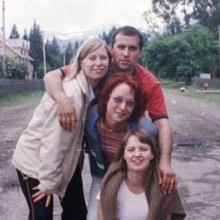 Group posing in rural village setting.