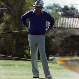 Man in vintage golf attire taking swing.