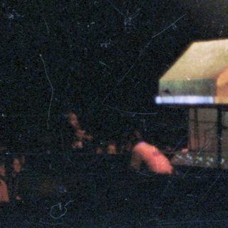 Person performing on stage with miniature houses.