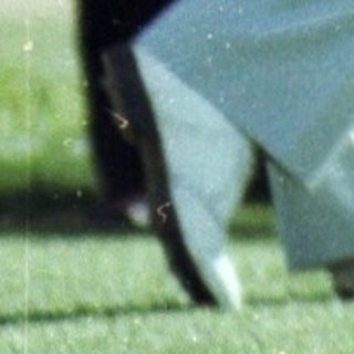 Golfer mid-swing on lush green course.