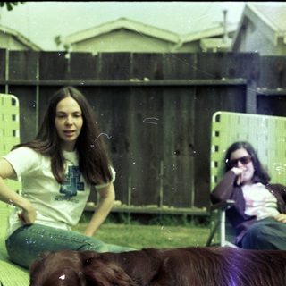 Two people relaxing outdoors with dog.