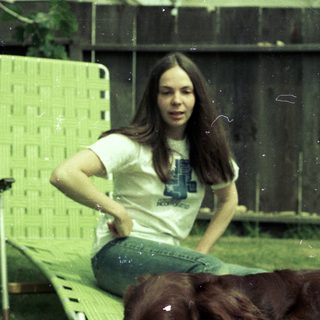 Two people relaxing outdoors with dog.