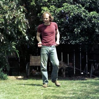 Man playing frisbee with dog outdoors.