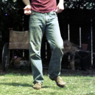 Man playing frisbee with dog outdoors.