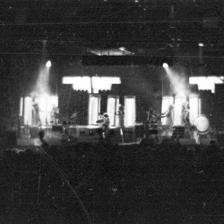 Live band performing on stage with stage lights.