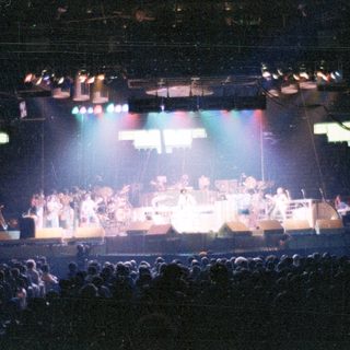 Live band performing on a brightly lit stage.