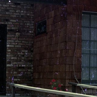 Small brick building with ramp, potted plants, and outdoor seating.