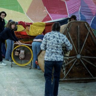 People preparing colorful hot air balloon.