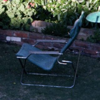 Child relaxing in outdoor lounge chair.