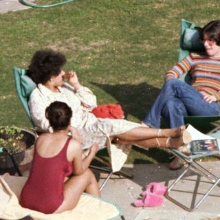 People relaxing by a backyard pool.