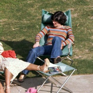 Family relaxing by a poolside on sunny day.