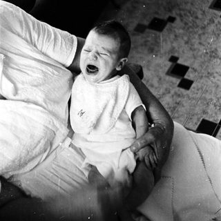 Baby crying while being held.