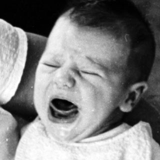 Baby crying while being held.