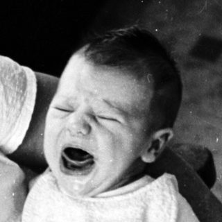 Baby crying while being held.