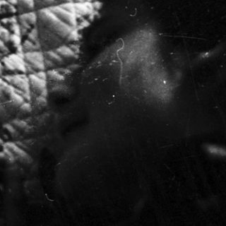 Baby crying in a crib with patterned fabric.