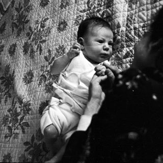 Baby being held and comforted indoors.