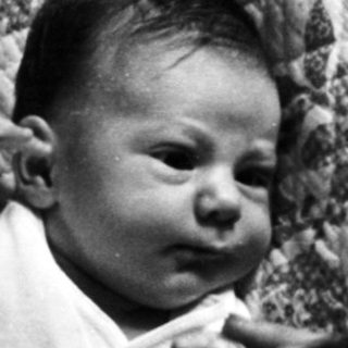 Infant crying while being held indoors.