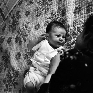 Infant crying while being held indoors.
