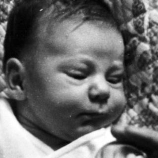 Infant lying on woven mat.