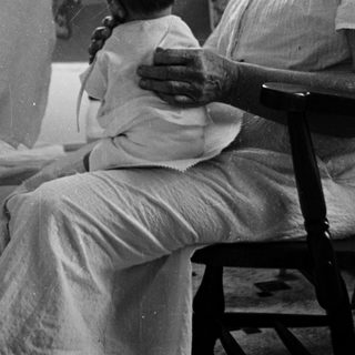 A man holds a baby in a hospital setting.