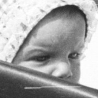 Baby in vintage pram with fishing net.