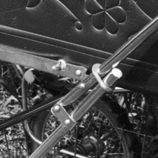Baby in vintage pram with fishing net.