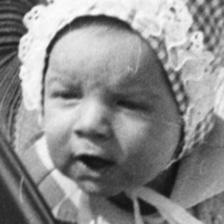 Baby in vintage pram outdoors.
