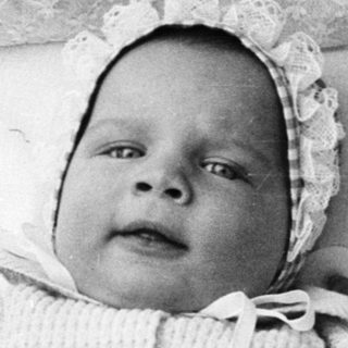 Baby in vintage pram, early 20th century.