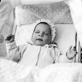 Baby in vintage pram, early 20th century.