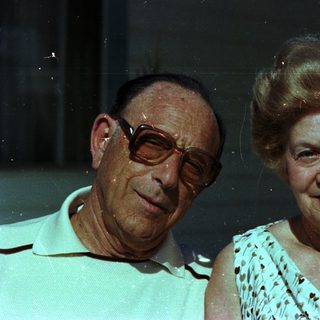 Happy elderly couple posing indoors at night.