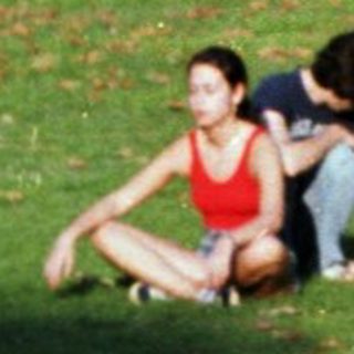 Two people sitting on grass park.