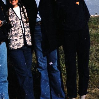Four people posing outdoors in casual attire.