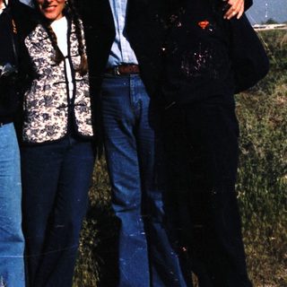 Four people posing outdoors in casual attire.