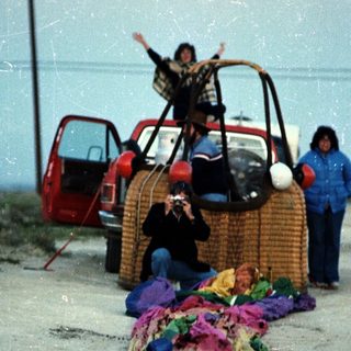 People playing with giant woven balls and colorful fabric.