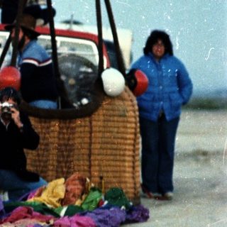 People playing with giant woven balls and colorful fabric.