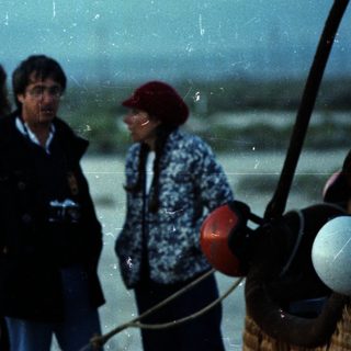 People standing near a hot air balloon.
