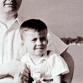 A man holding a young boy outdoors.