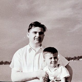 A man holding a young boy outdoors.