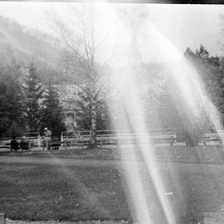 Vintage photo of park with fountain and people.