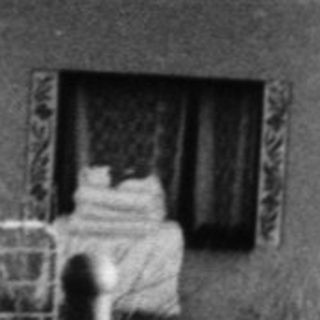 Black-and-white photo of children near a fenced house.