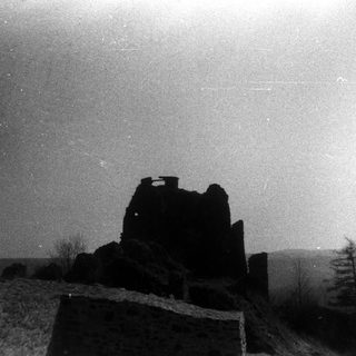 Ruins of a castle under starlit night sky.