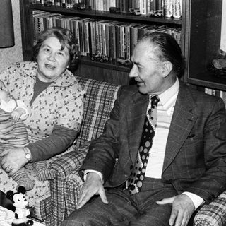 Family portrait with elderly couple and baby indoors.