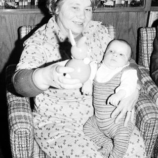 Woman holding baby in arm indoors.