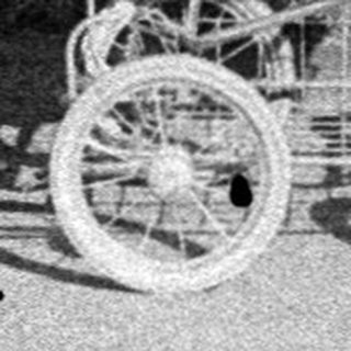 A woman in vintage clothing pushes an old-fashioned baby carriage outdoors.