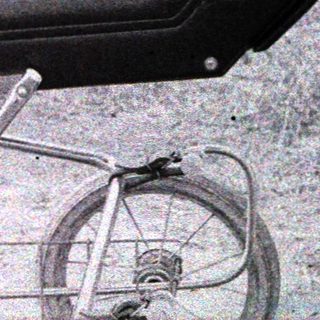 Baby carriage with open canopy showing infant inside.