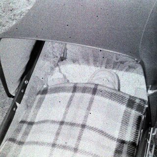 Vintage car seat with plaid cover.