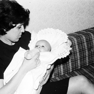 Woman feeding baby with bottle.